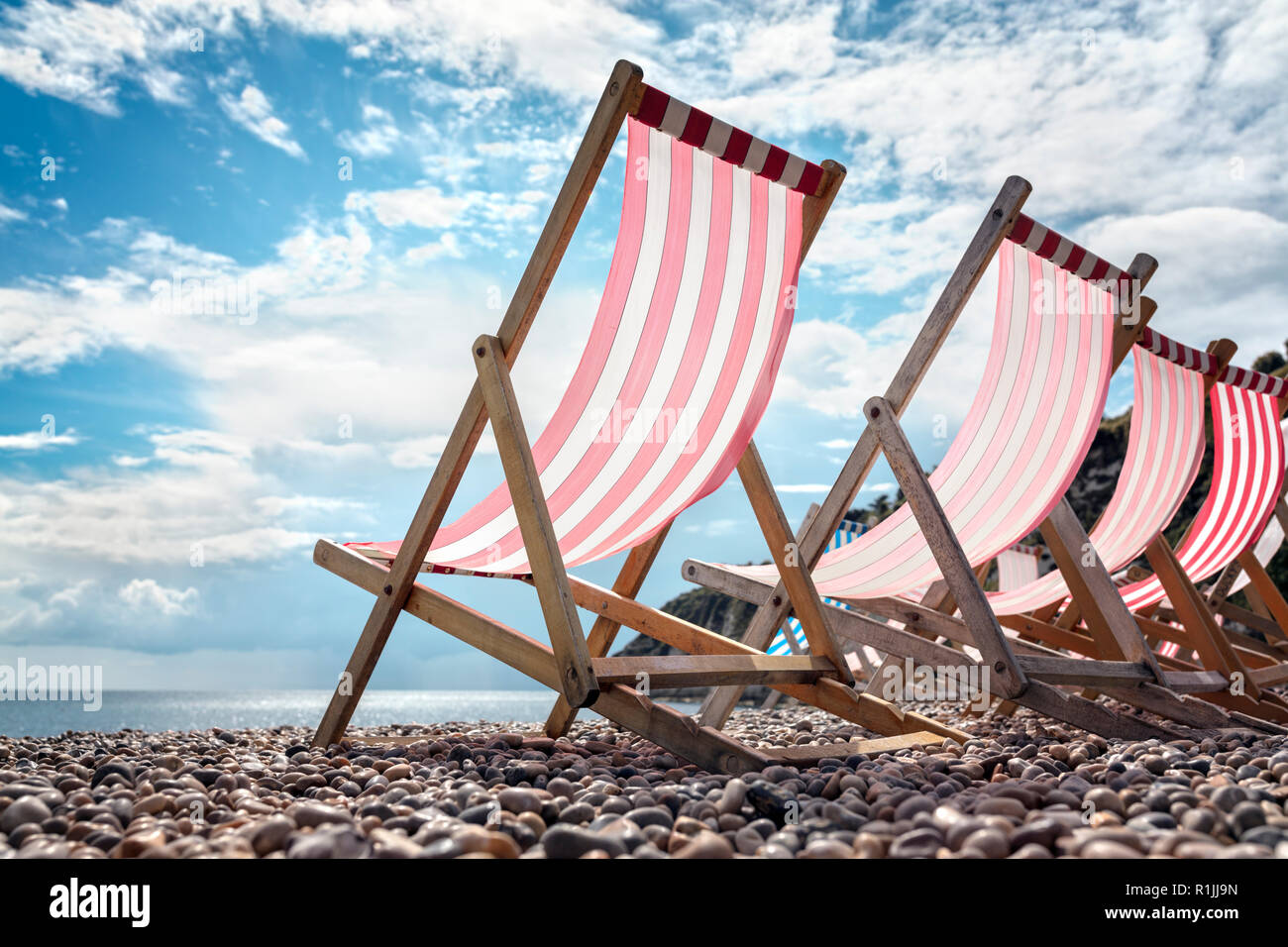 Sedie a sdraio sulla spiaggia in riva al mare su vacanze estive Foto Stock