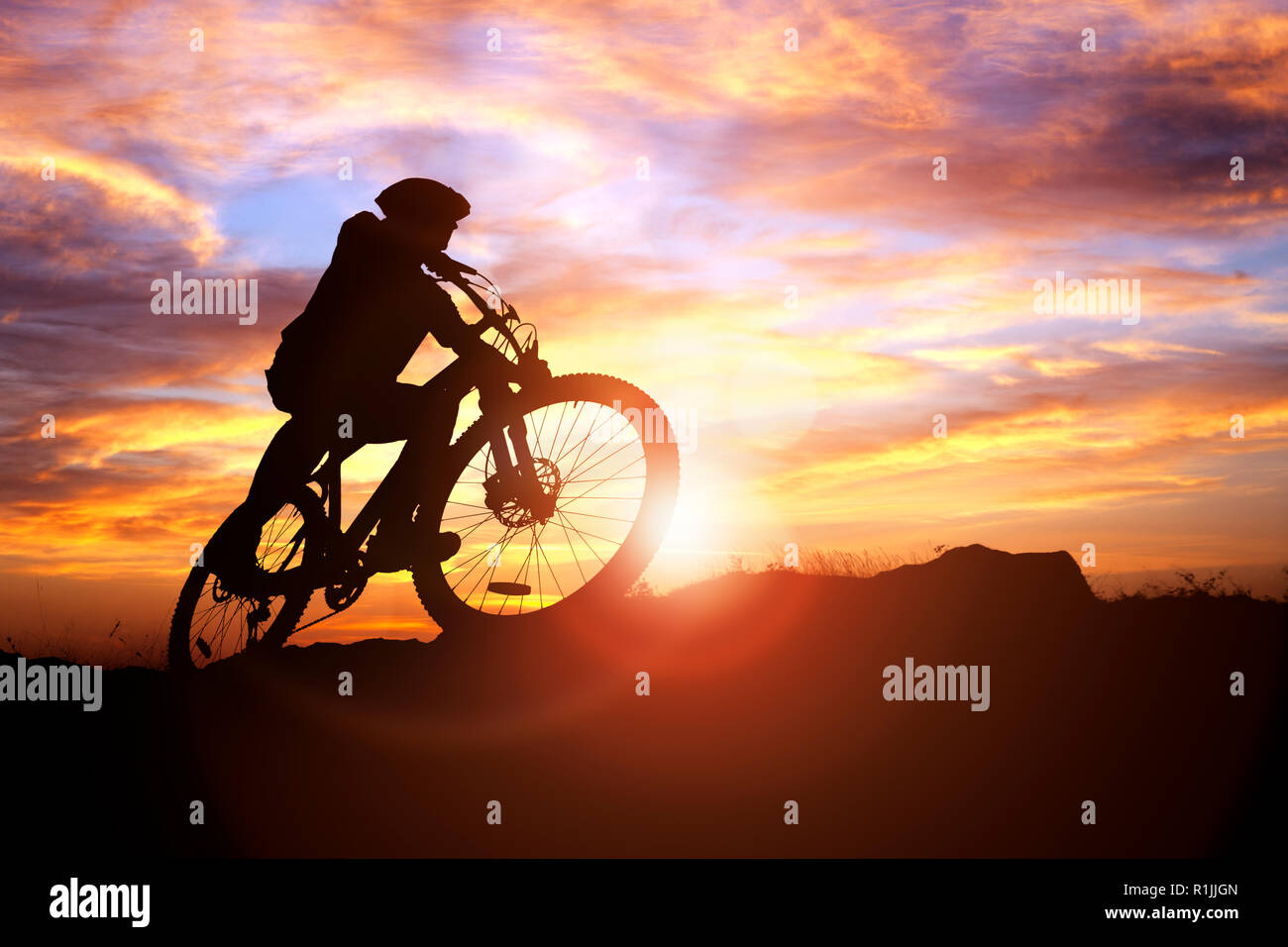 Mountain Biker silhouette contro il concetto di tramonto per conseguimento, conquistando le avversità e di esercizio Foto Stock