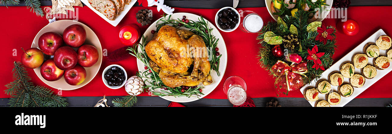 La Turchia al forno. Cena di Natale. La tavola del Natale è servita con una Turchia, decorate con colori luminosi tinsel e candele. Pollo fritto, tabella. Famiglia d Foto Stock