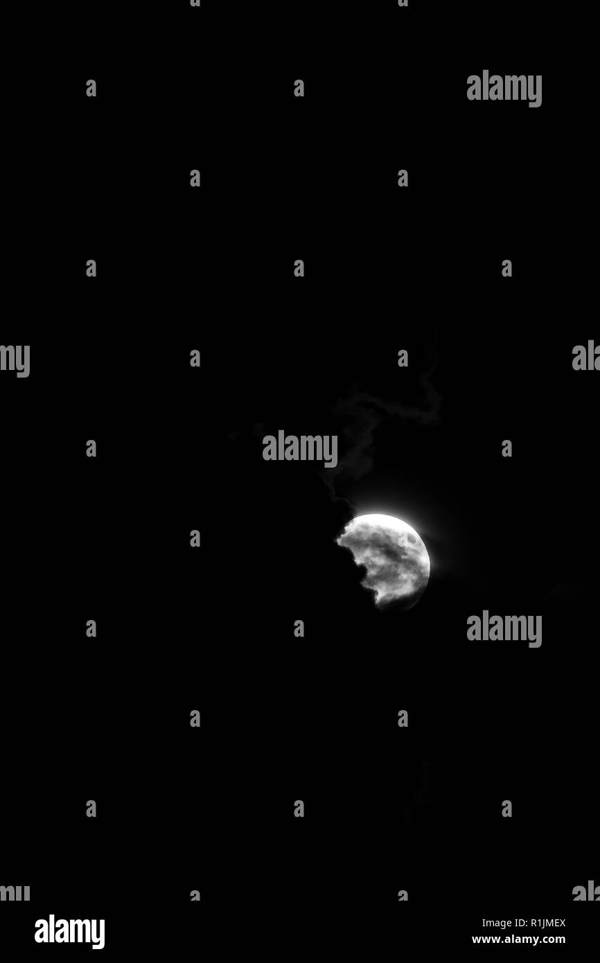 Fotografia in bianco e nero di luna di sangue prima di eclipse, prese in consegna la Bulgaria, sullo spesso cielo nero la notte del 26 luglio 2018 parzialmente nascosta Foto Stock