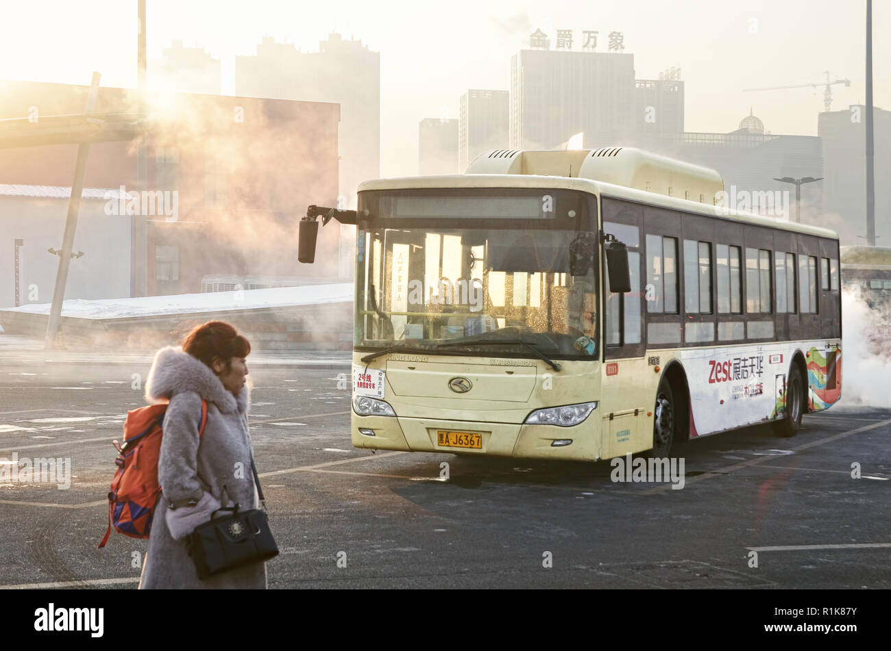 Donna passeggero e il bus pubblico in area di parcheggio di Harbin Stazione Ferroviaria Ovest Foto Stock