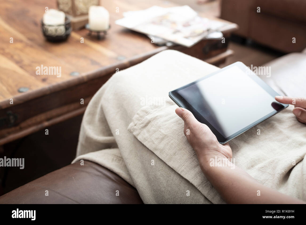 Donna seduta al chiuso tenendo l'Ipad. Web design mockup Foto Stock