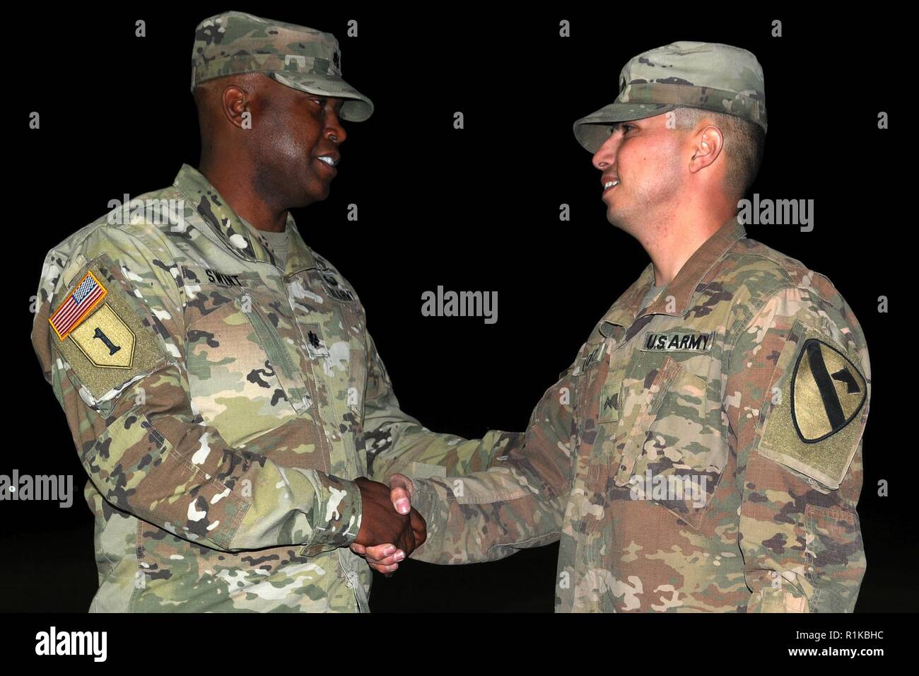 Stati Uniti Esercito Lt. Col. Kelvin Swint, sinistra, comandante del battaglione del secondo battaglione, quinto reggimento di cavalleria, 1° Brigata corazzate contro la squadra, 1° Divisione di cavalleria si congratula con gli Stati Uniti Esercito Cpl. Angel Vazquez, una alimentazione sergente assegnato alla società di Charlie, 2-5 CAV, dopo Vazquez, che ha ottenuto il punteggio più alto nel battaglione di comando della disciplina di alimentazione ispezione, reenlists durante la spada della giustizia a Smardan Area Formazione, Romania, Ottobre 12, 2018. I soldati del battaglione sono distribuiti in Europa a sostegno di Atlantic risolvere, il permanere di un esercizio di formazione tra la NATO e le forze americane. Foto Stock