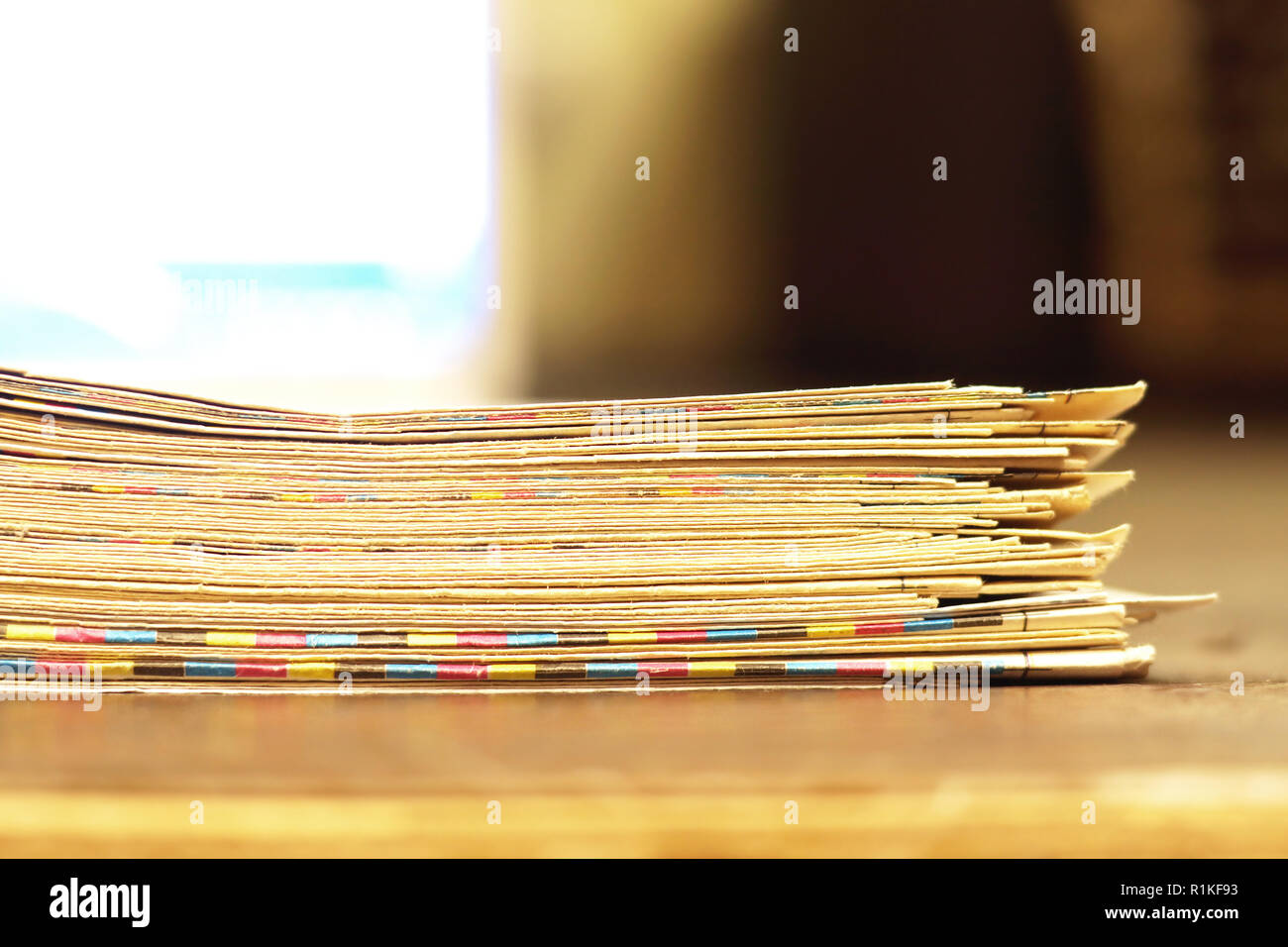 Texture di vecchi giornali con giallo piegato grungy pagine impilate in grande pila contro luce sfondo sfocato, close up Foto Stock
