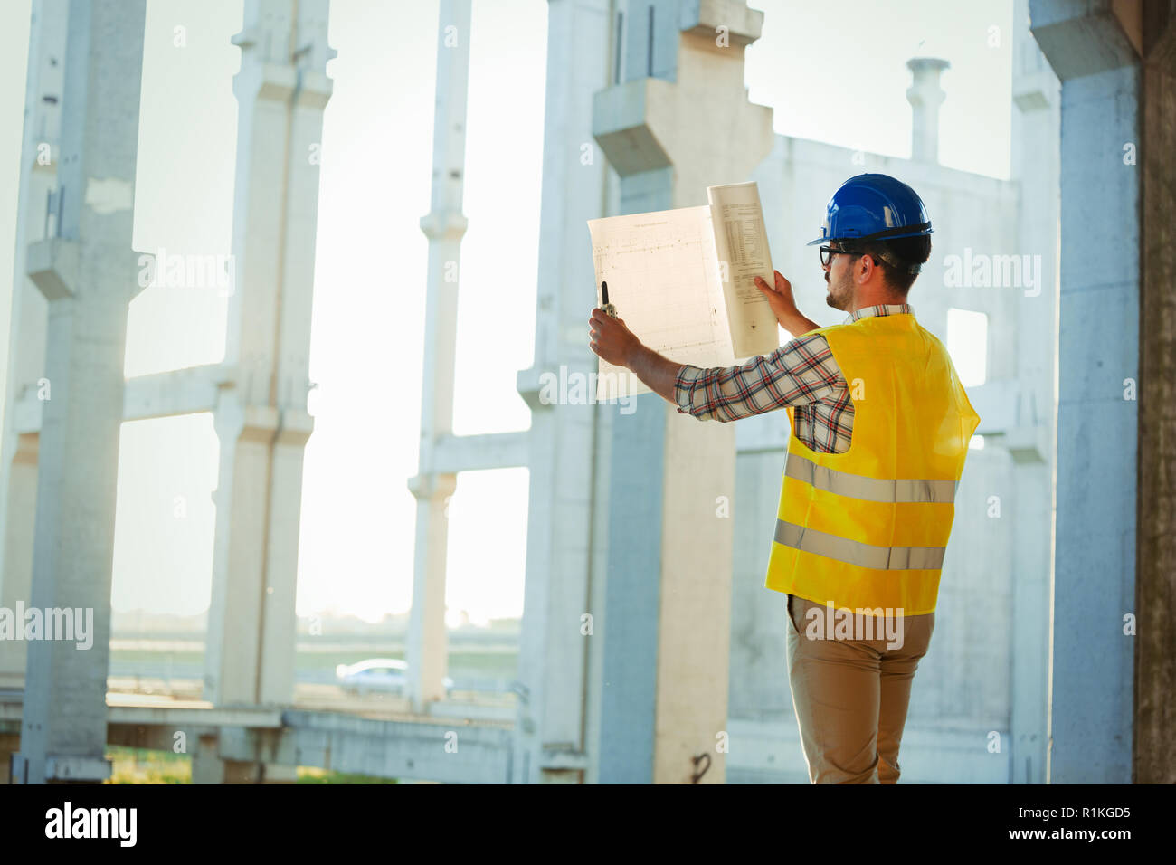 Immagine del sito in costruzione ingegnere guardando al plan Foto Stock