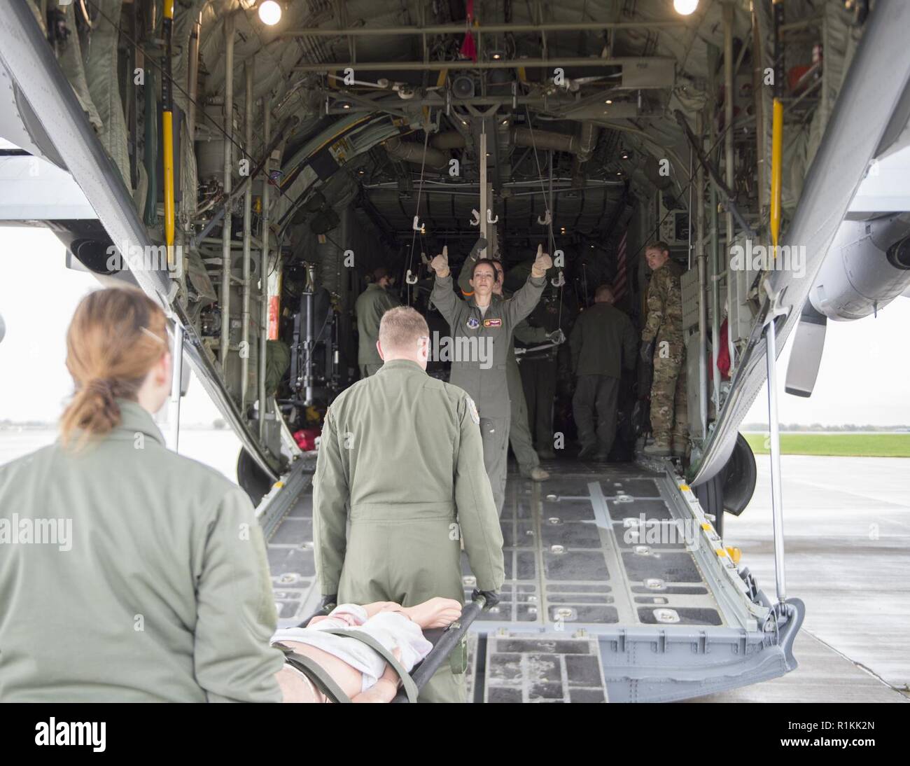 Stati Uniti Air Force Il Mag. Meghan boiacca, 109 di medicina aeronautica squadrone di evacuazione, dà istruzioni sul caricamento di un C-130 Hercules in St. Paul, Minn., Ottobre 9, 2018. Intonachi è un volo infermiere, che è responsabile per la pianificazione della missione e fornire cure mediche essenziali ai pazienti mentre viene trasportato su un aeromobile. Foto Stock