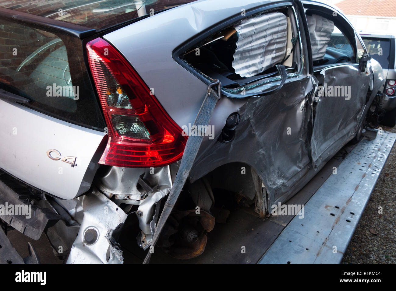 Tre quarti di vista posteriore di scritti off crash danneggiato citroen c4 auto su un rimorchio di recupero Foto Stock