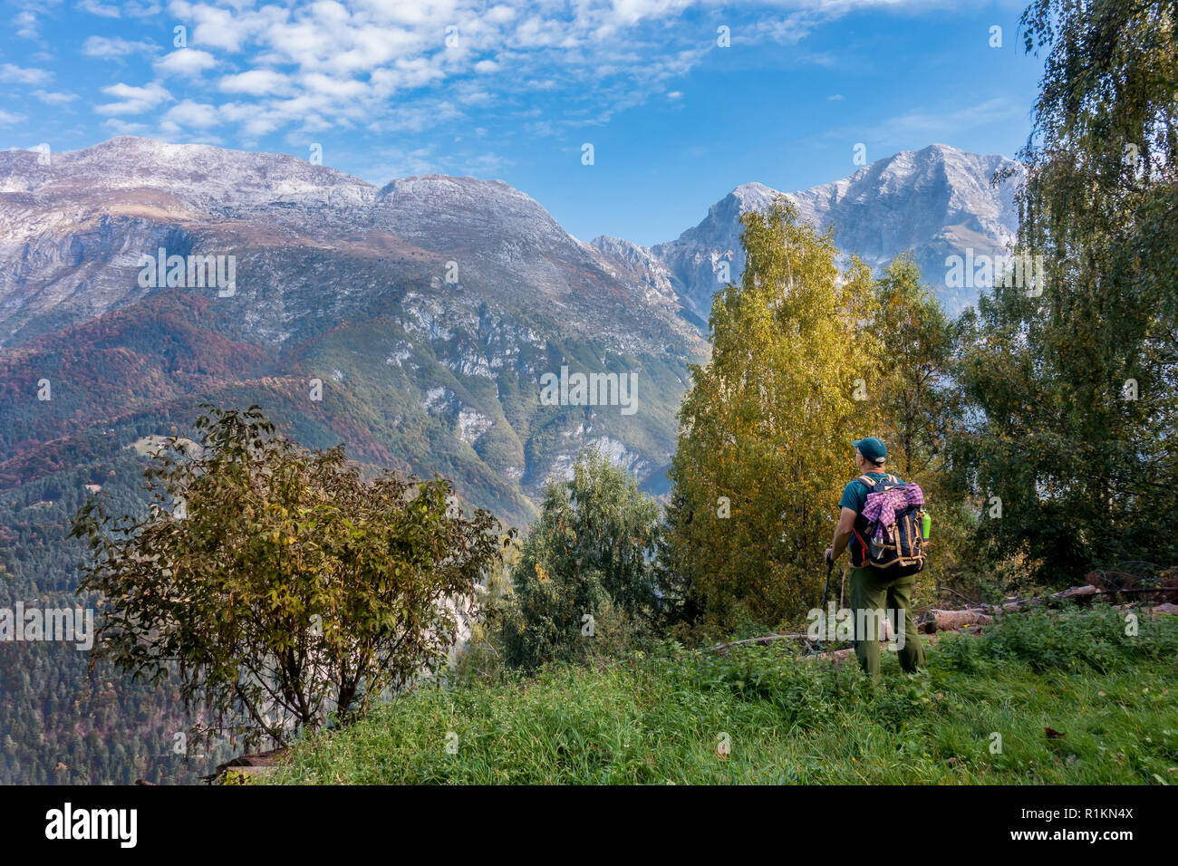 L'uomo escursionista guarda il paesaggio di montagna in autunno Foto Stock