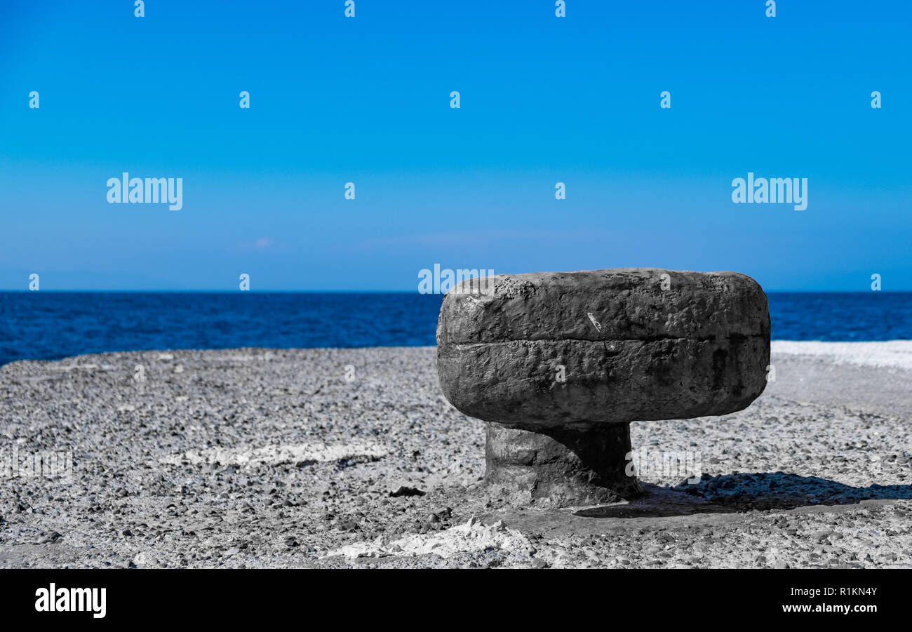 Vecchio arrugginito bollard su un molo sul mare in Grecia Foto Stock