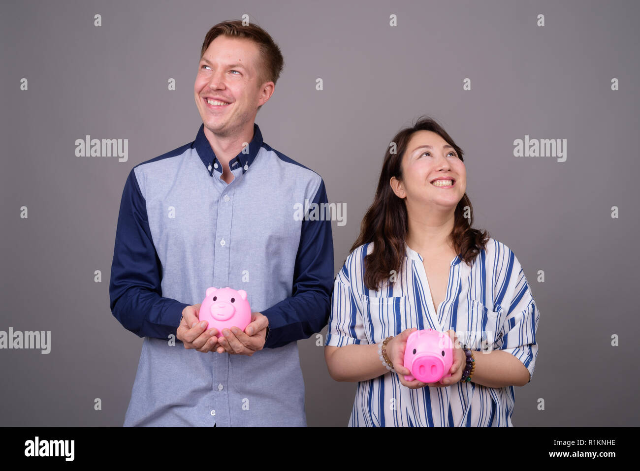 Ritratto di giovane azienda salvadanaio in mano mentre pensando Foto Stock