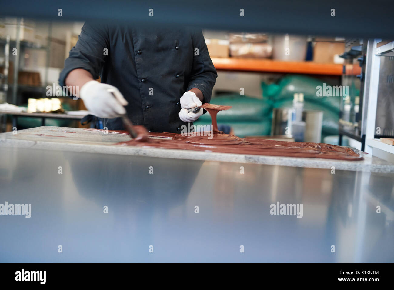 Pasticceria artigianale maker diffusione di cioccolato fuso su un tavolo Foto Stock