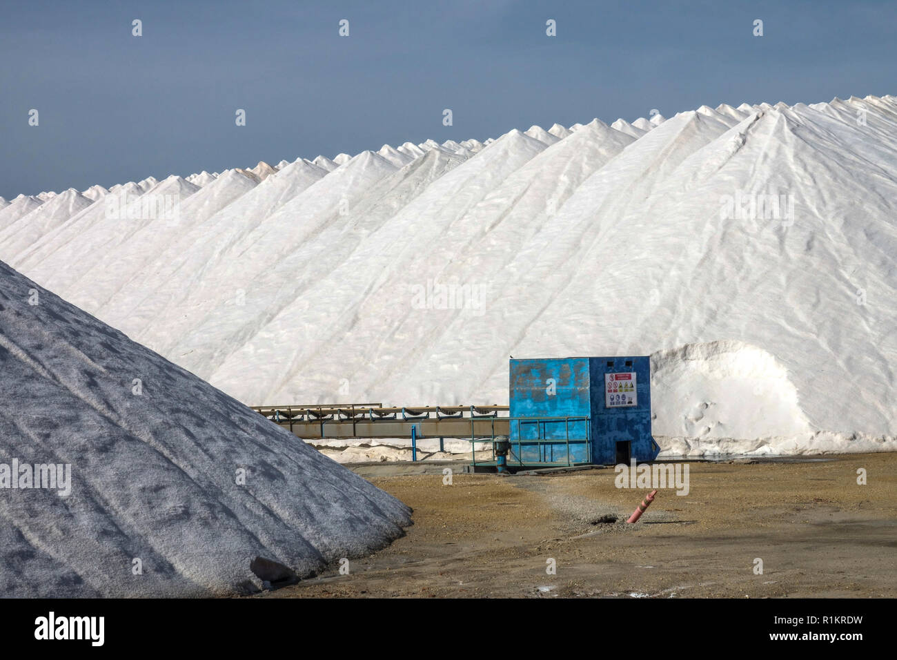 Sale della Spagna, Santa Pola, Heap di sale marino, capannone blu in pali di sodio bianchi Foto Stock