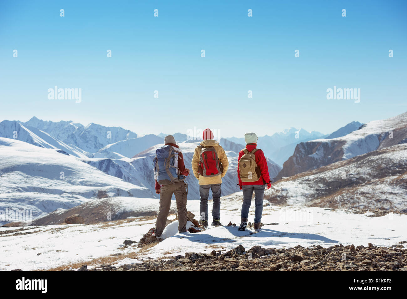 Tre turisti sorge sulla sommità di mountain pass e guarda a vista Foto Stock