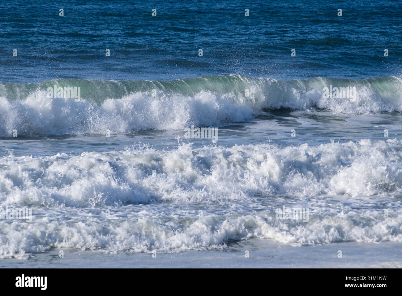 ​​Waves del mare che si infrangono sulla riva della spiaggia di spruzzi e la formazione di schiuma Foto Stock