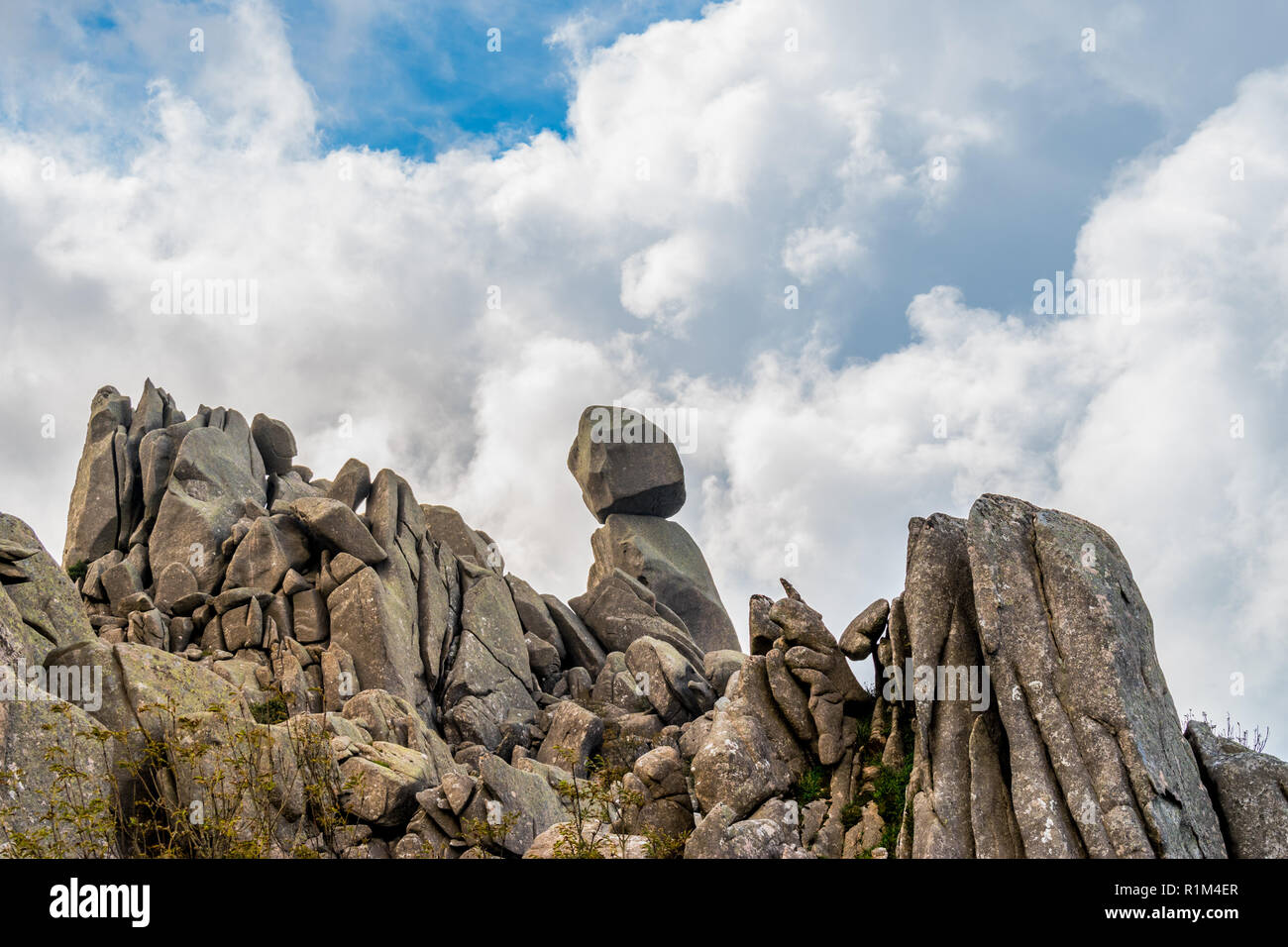 Vista ingrandita di Omu di Cagna (Uomo di Cagna) sull'isola di Corsica. La roccia di granito è equilibrato alla sommità di un picco sulla montagna di cagna. Foto Stock