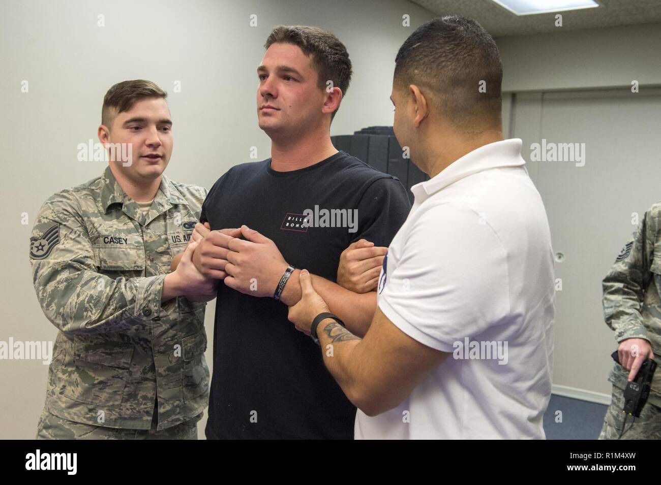 Stati Uniti Air Force Staff Sgt. Sean Casey, sinistra e Diego Laredo, diritto, bretella Josh Eldridge prima di condurre Taser familiarizzazione della formazione a base comune, Alaska, 18 ottobre 2018. Tasers fornire JBER difensori con un non-arma letale che può sottomettere la fuga, belligerante, o potenzialmente pericolose, le persone che sarebbero state altrimenti sottoposto a più letali armi quali armi da fuoco. Casey, Laredo, e Eldridge sono funzionari di polizia assegnato alla 673d delle forze di sicurezza Squadron. Foto Stock