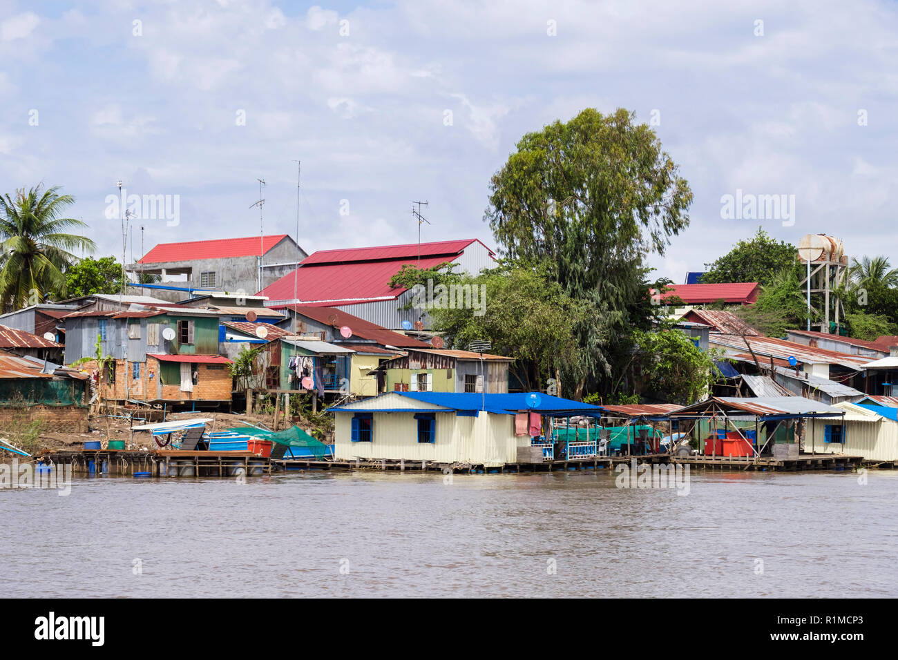 Baraccopoli tipico stagno ondulato case su palafitte nel villaggio di pescatori lungo il fiume Mekong. Cambogia, sud-est asiatico Foto Stock