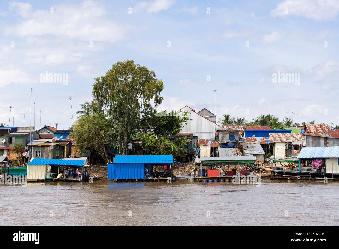 Tipiche Case di stagno su palafitte in baraccopoli bidonville villaggio lungo il fiume Mekong. Cambogia, sud-est asiatico Foto Stock
