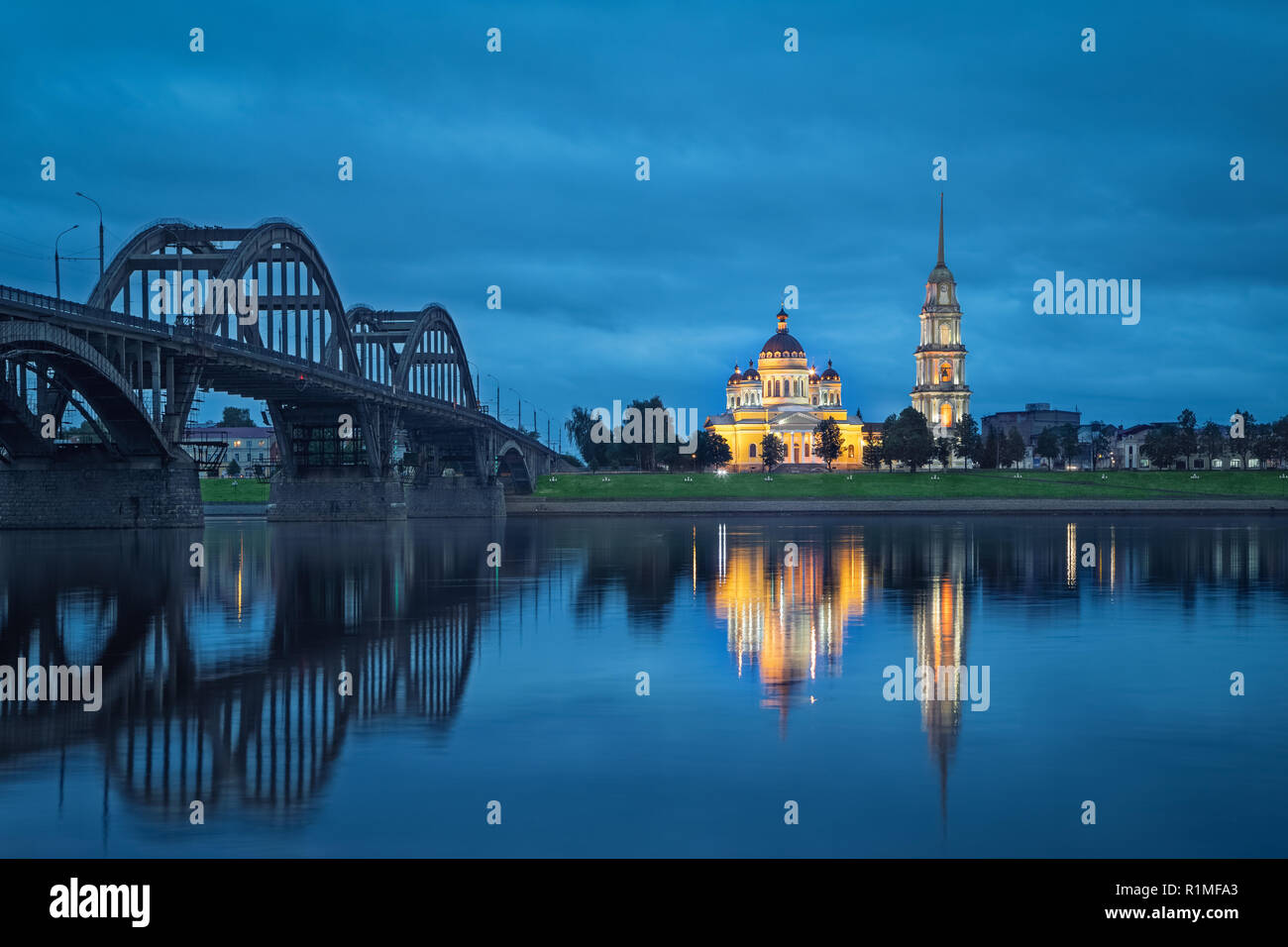 Rybinsk, Russia. Spaso-Preobrazhenskiy cattedrale e il ponte sul fiume Volga riflettendo in acqua a dsuk Foto Stock