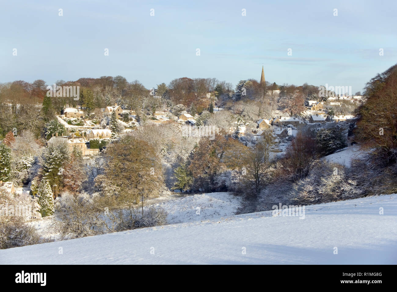 Inghilterra, Gloucestershire, Cotswolds, sole invernale sul pittoresco villaggio di Bisley sotto una coltre di neve Foto Stock