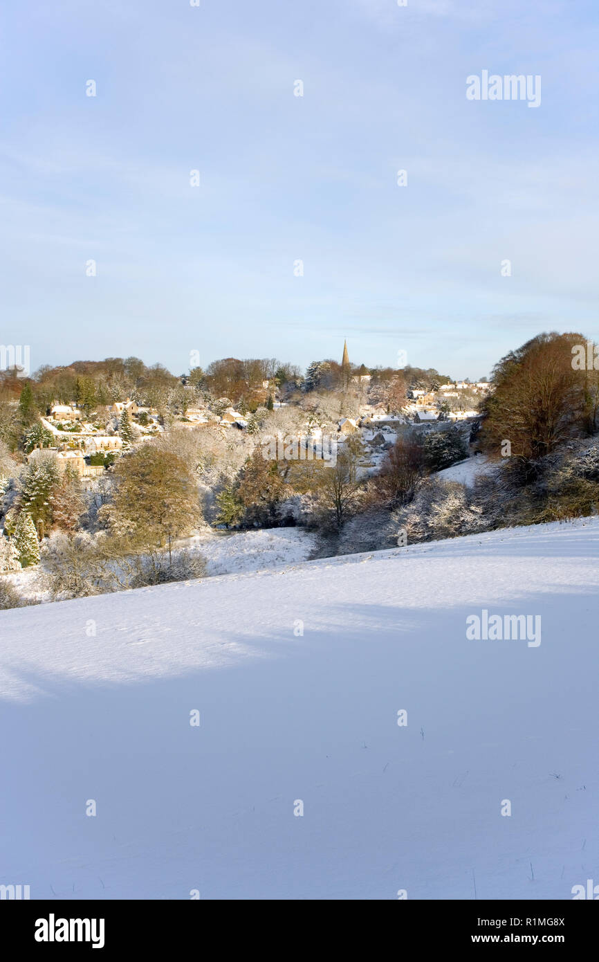 Inghilterra, Gloucestershire, Cotswolds, sole invernale sul pittoresco villaggio di Bisley sotto una coltre di neve Foto Stock