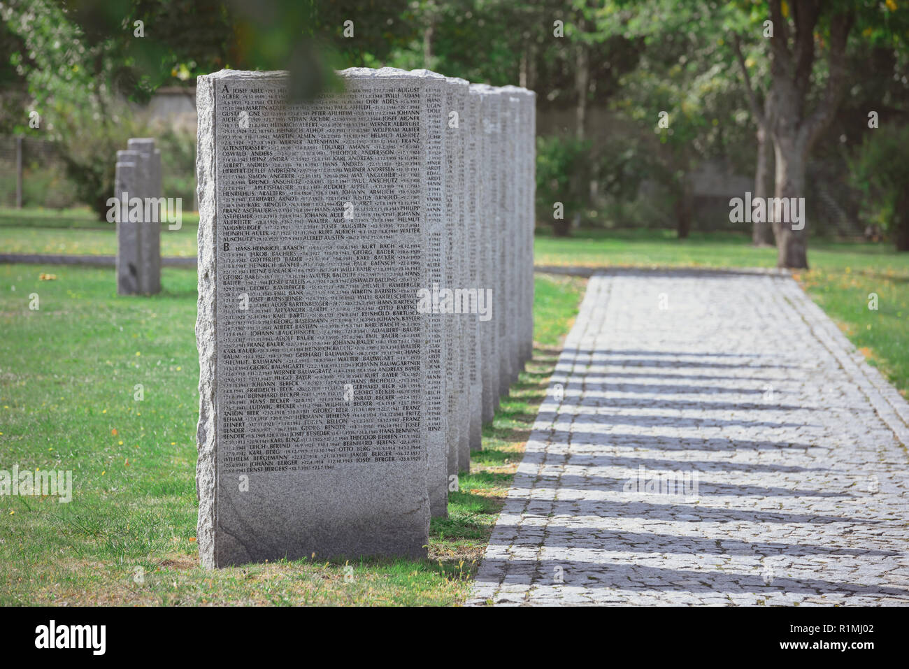 Identica di tombe con scritte poste in fila al cimitero Foto Stock