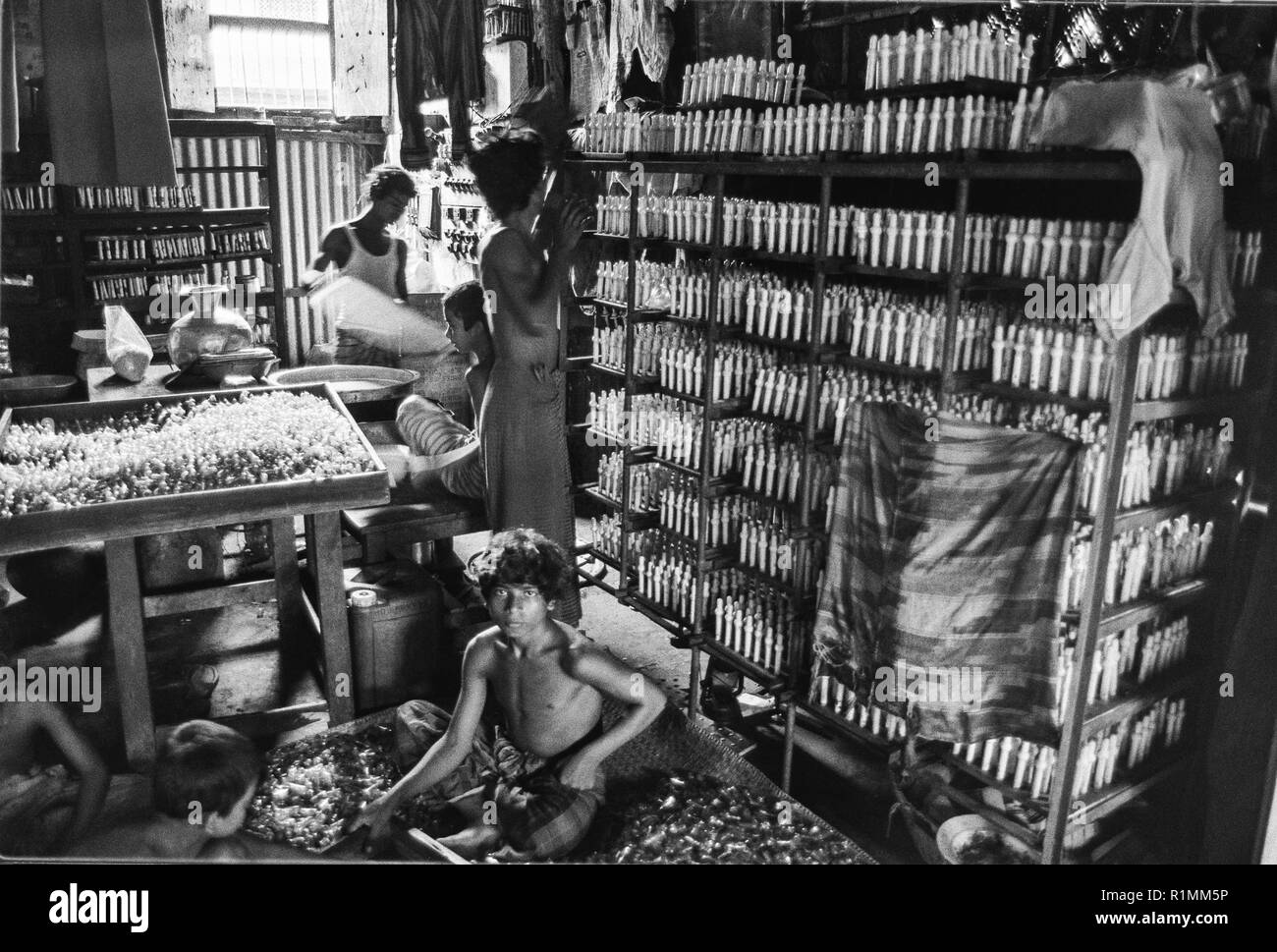 80/27 bambini lavoratori in fabbrica per rendere le tettarelle per biberon, Old Dhaka 1980 Foto Stock