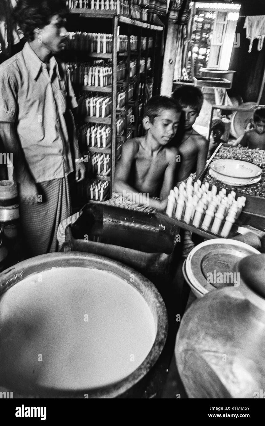80/33 bambini lavoratori in fabbrica per rendere le tettarelle per biberon, Old Dhaka 1980 Foto Stock