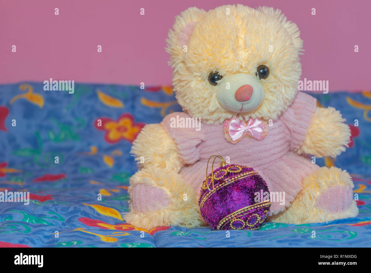 Orange orsacchiotto con albero di natale decorazione su un letto in una stanza dei bambini Foto Stock