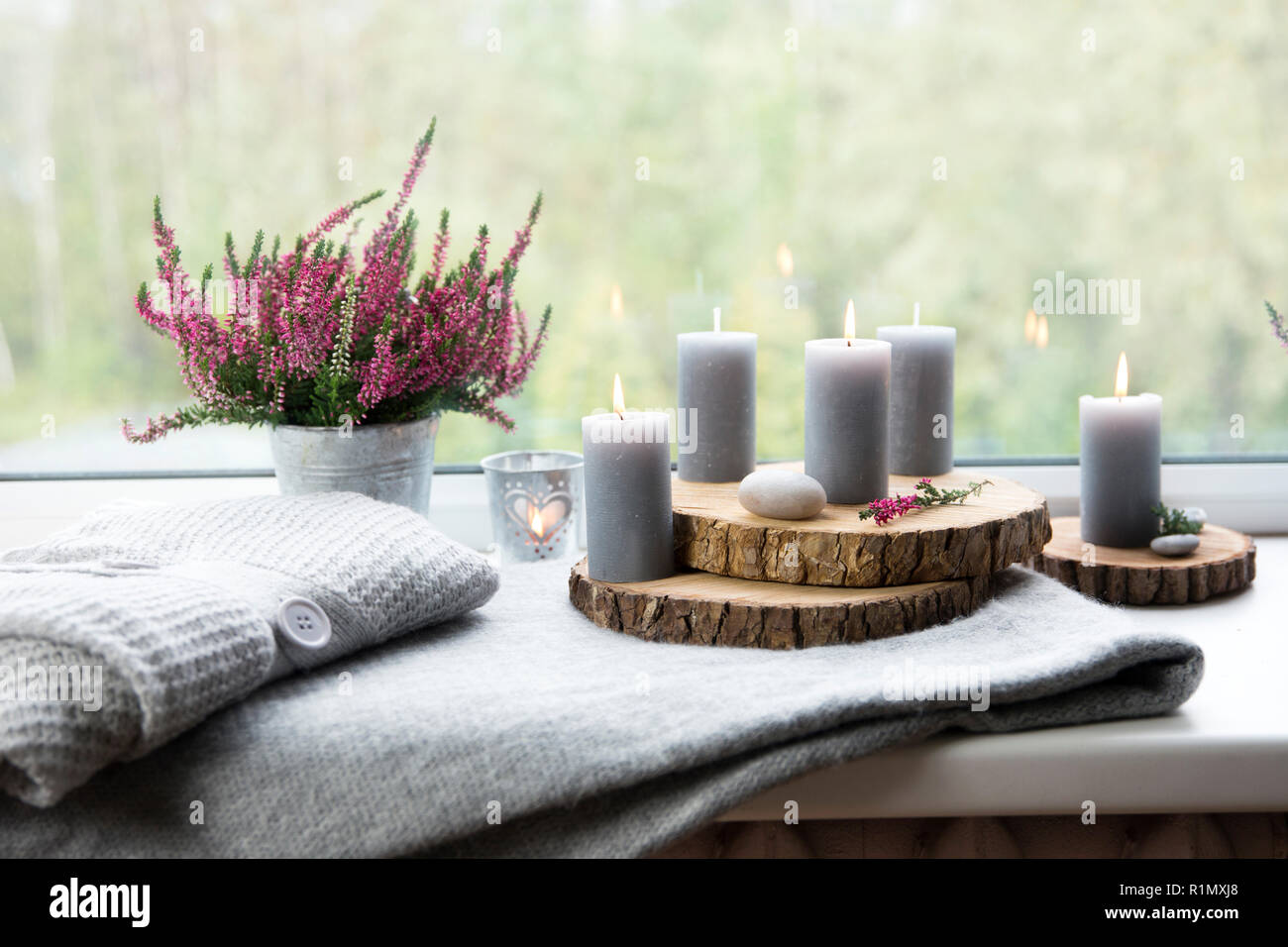 Pronto per l'autunno. Comune di heather fiore nel vaso di zinco, home decor idea. Set di accoglienti decorazioni stagionali sul davanzale. Grigio a candele accese, tavola di legno Foto Stock