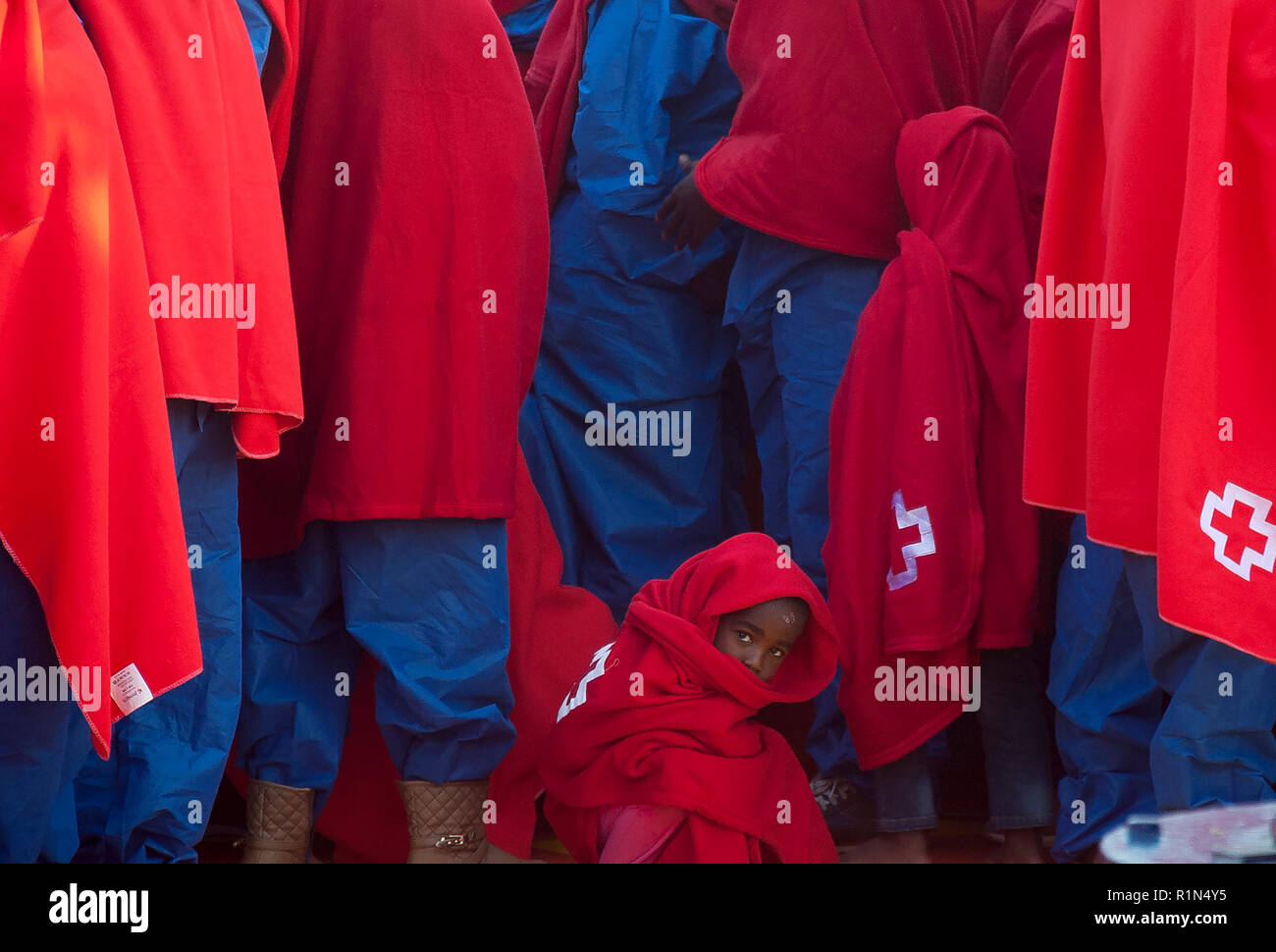 Un bambino migrante si vede guardando su dopo il suo arrivo al porto di Malaga. Spagna's Maritime Rescue service salvato 176 migranti a bordo di gommoni al Mar Mediterraneo e li ha portati al porto di Malaga dove essi sono stati assistiti dalla Croce Rossa spagnola. Foto Stock