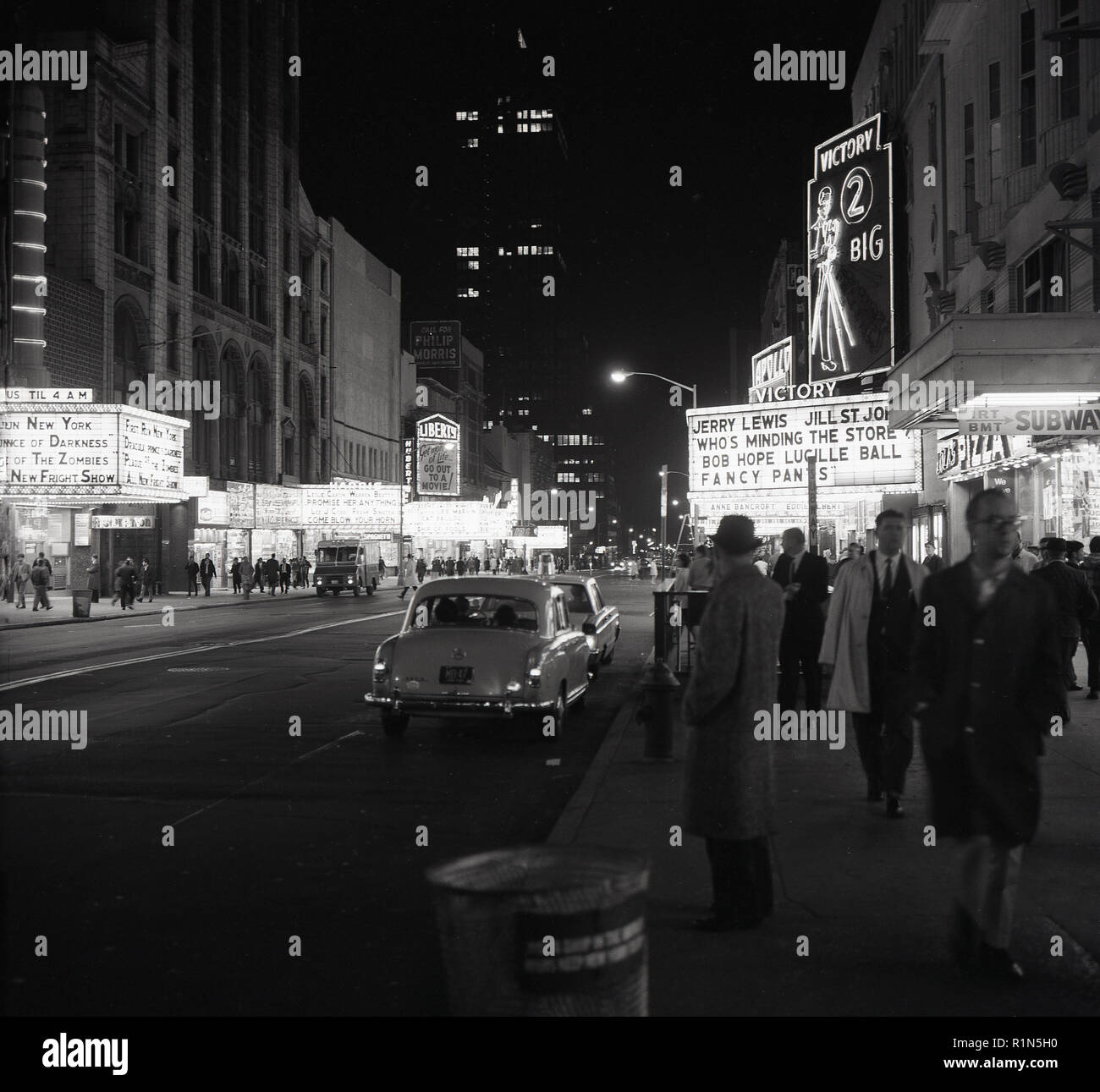 Degli anni Cinquanta, storico, Manhattan, New York City e una vista di Times Square in serata che mostra il cinema con alcune delle più grandi stelle del cinema dell'epoca. Foto Stock