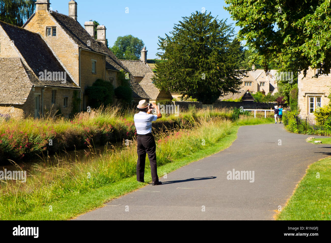 Lower Slaughter, Gloucestershire, Regno Unito - 19 Luglio 2016: sole estivo porta i visitatori al pittoresco villaggio Costwold di Lower Slaughter, Gloucestershire, UK. Il villaggio si trova a cavallo del fiume piccolo occhio e diversi piccoli ponti pedonali e una Ford unire i due lati della comunità. Foto Stock