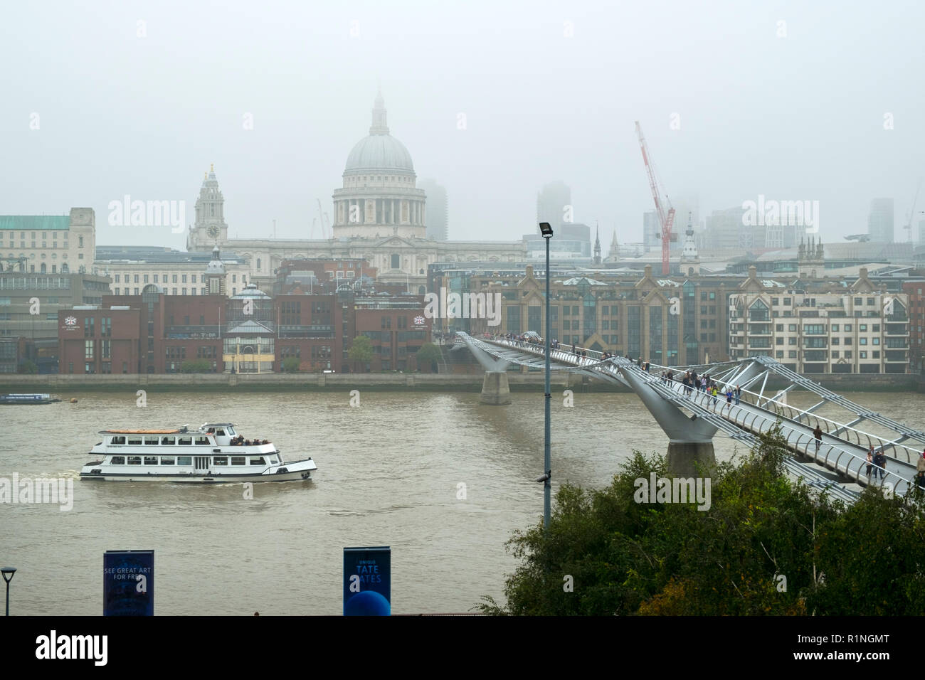 London, Regno Unito - 30 Ottobre 2016: Guardando al di là del fiume Tamigi e il London Millennium passerella verso St Pauls Cathedral e la città di Londra su un nebbioso giorno di autunno Foto Stock