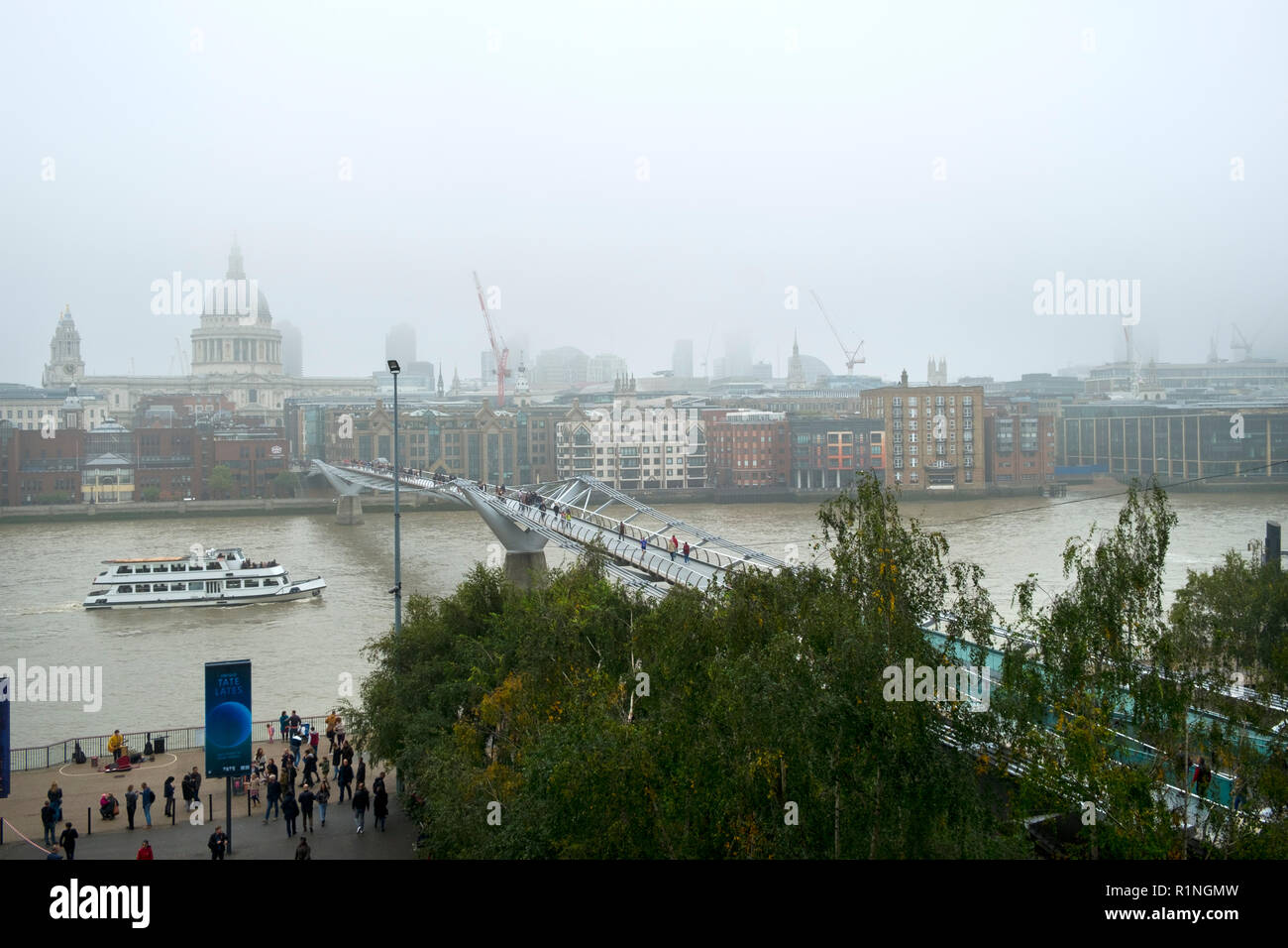London, Regno Unito - 30 Ottobre 2016: Guardando al di là del fiume Tamigi e il London Millennium passerella verso St Pauls Cathedral e la città di Londra su un nebbioso giorno di autunno Foto Stock