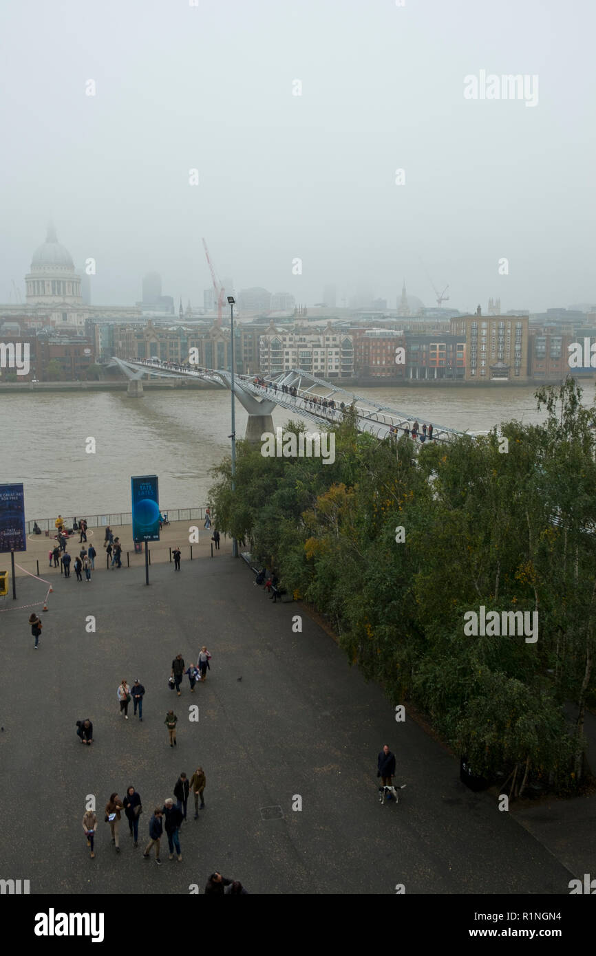 London, Regno Unito - 30 Ottobre 2016: Guardando al di là del fiume Tamigi e il London Millennium passerella verso St Pauls Cathedral e la città di Londra su un nebbioso giorno di autunno Foto Stock