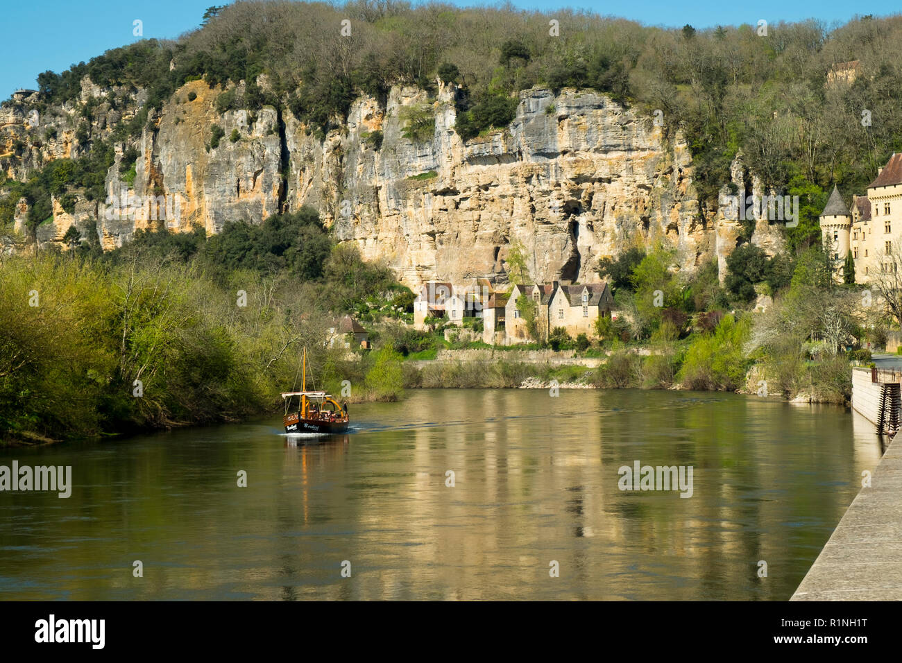 La Roque-Gageac, Francia - 3 Aprile 2017: un giro turistico in battello passa La Roque-Gageac sul fiume Dordogna in Dordogne, Nouvelle Aquitaine, Francia. È un membro del Les Plus Beaux Villages de France Foto Stock