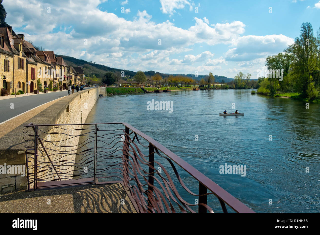 La Roque-Gageac, Francia - 3 Aprile 2017: canoe passano La Roque-Gageac accanto al fiume Dordogne in Dordogne, Nouvelle Aquitaine, Francia. È un membro del Les Plus Beaux Villages de France ("i più bei villaggi di Francia ") l'associazione. Foto Stock