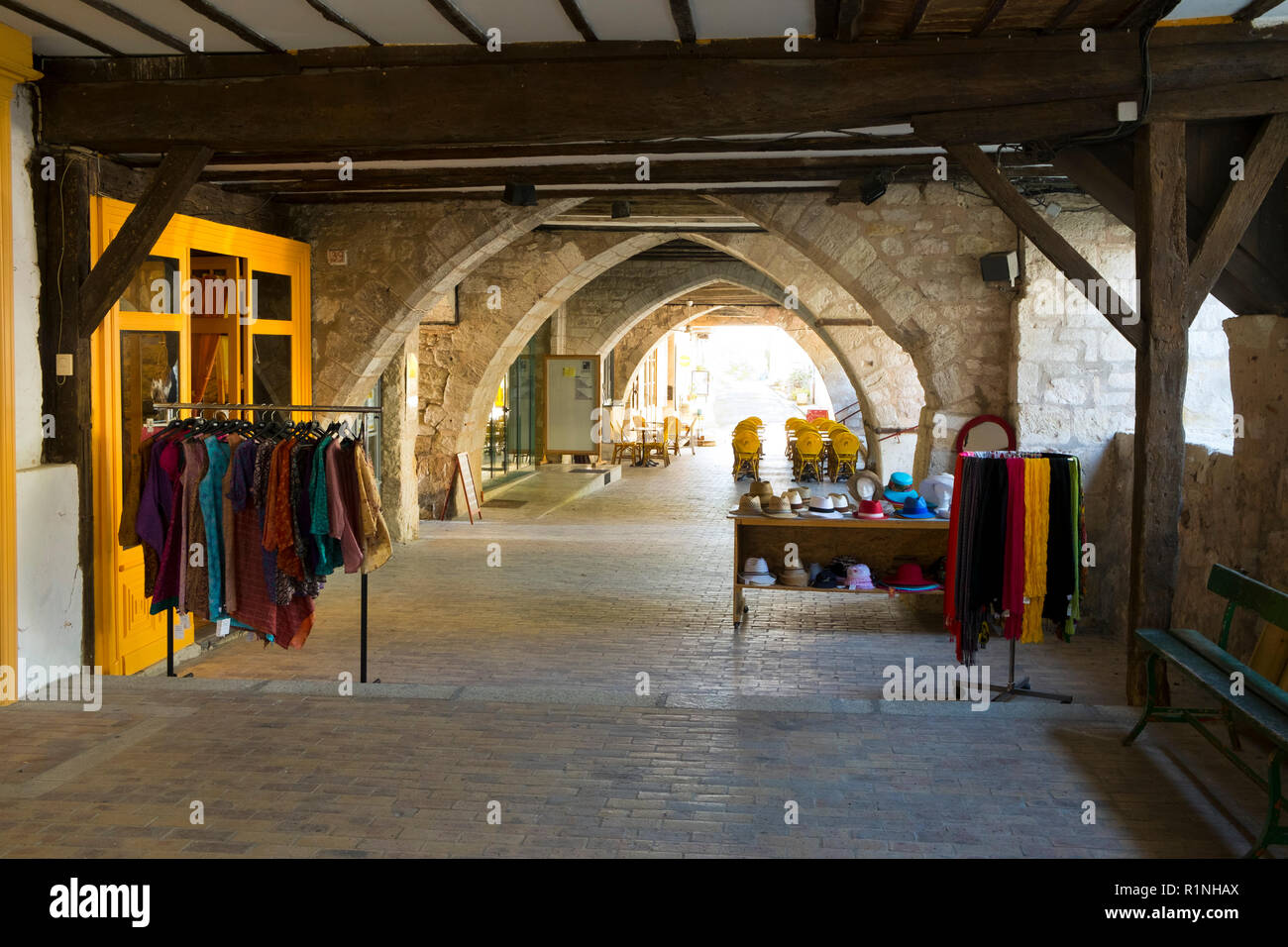 Monflanquin, Francia - 6 Aprile 2017: sotto i portici di Place des Arcades' centrale piazza Monflanquin Lot-et-Garonne, Francia. Questa pittoresca città è un membro dei più bei villaggi di Francia (Les Plus Beaux Villages de France) associazione ed è pensato per essere uno dei più storicamente intatto esempi di una bastide medievale città. Foto Stock