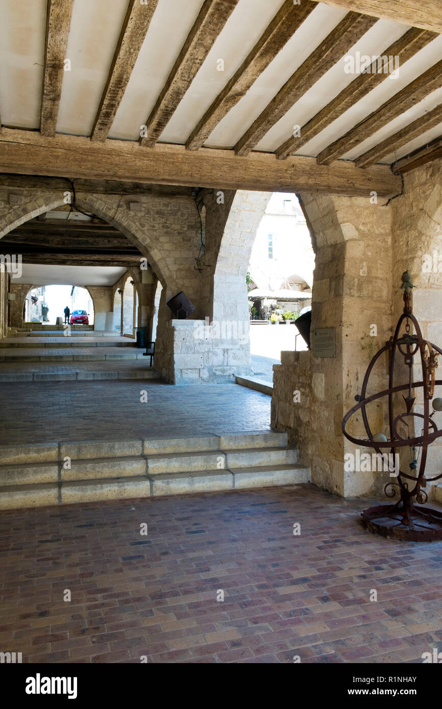 Monflanquin, Francia - 6 Aprile 2017: sotto i portici di Place des Arcades' centrale piazza Monflanquin Lot-et-Garonne, Francia. Questa pittoresca città è un membro dei più bei villaggi di Francia (Les Plus Beaux Villages de France) associazione ed è pensato per essere uno dei più storicamente intatto esempi di una bastide medievale città. Foto Stock