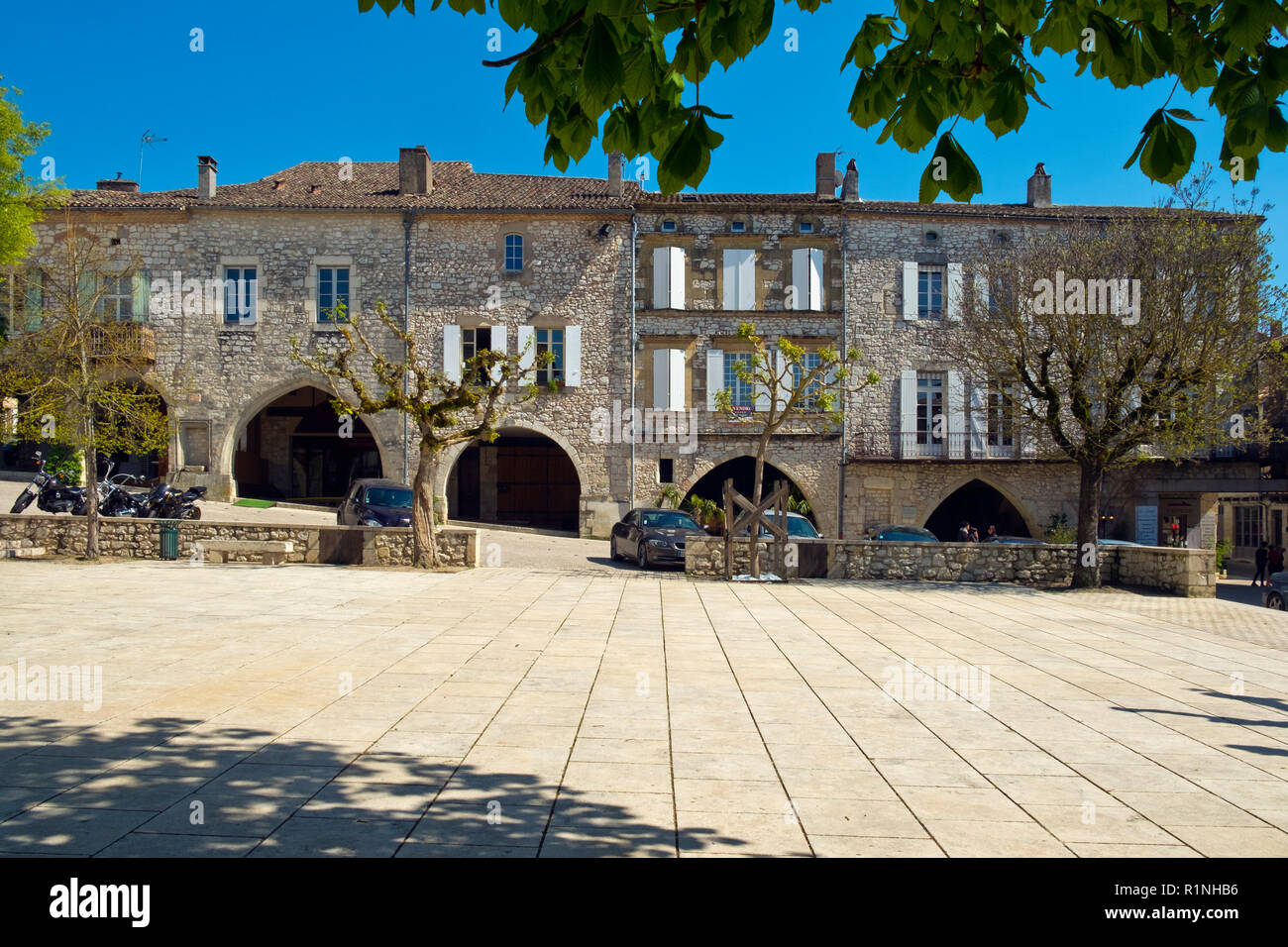 Monflanquin, Francia - 6 Aprile 2017: architettura storica del 'Place des Arcades' centrale piazza Monflanquin Lot-et-Garonne, Francia. Questa pittoresca città è un membro dei più bei villaggi di Francia (Les Plus Beaux Villages de France) associazione ed è pensato per essere uno dei più storicamente intatto esempi di una bastide medievale città. Foto Stock
