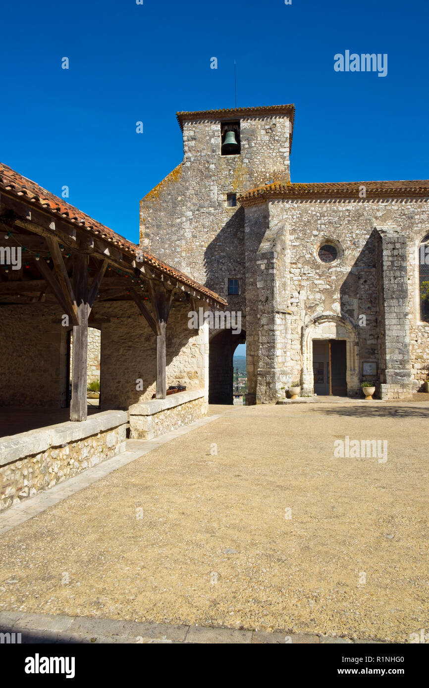 Il mercato coperto e la chiesa in srping sunshine a Pujols, Lot-et-Garonne, Francia. Questo storico villaggio fortificato di Rocca è ora un membro del "Les Plus Beaux Villages de France' Association. Foto Stock