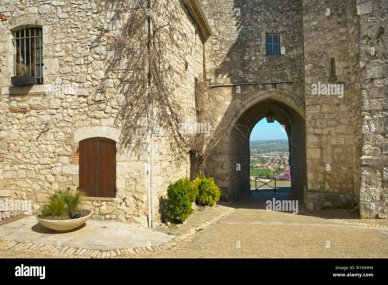 Guardando attraverso l'arco a Saint Nicholas campanile alla vista di Villeneuve-sur-lotto, Pujols, Lot-et-Garonne, Francia. Questo storico villaggio fortificato di Rocca è ora un membro del "Les Plus Beaux Villages de France' Association. Foto Stock