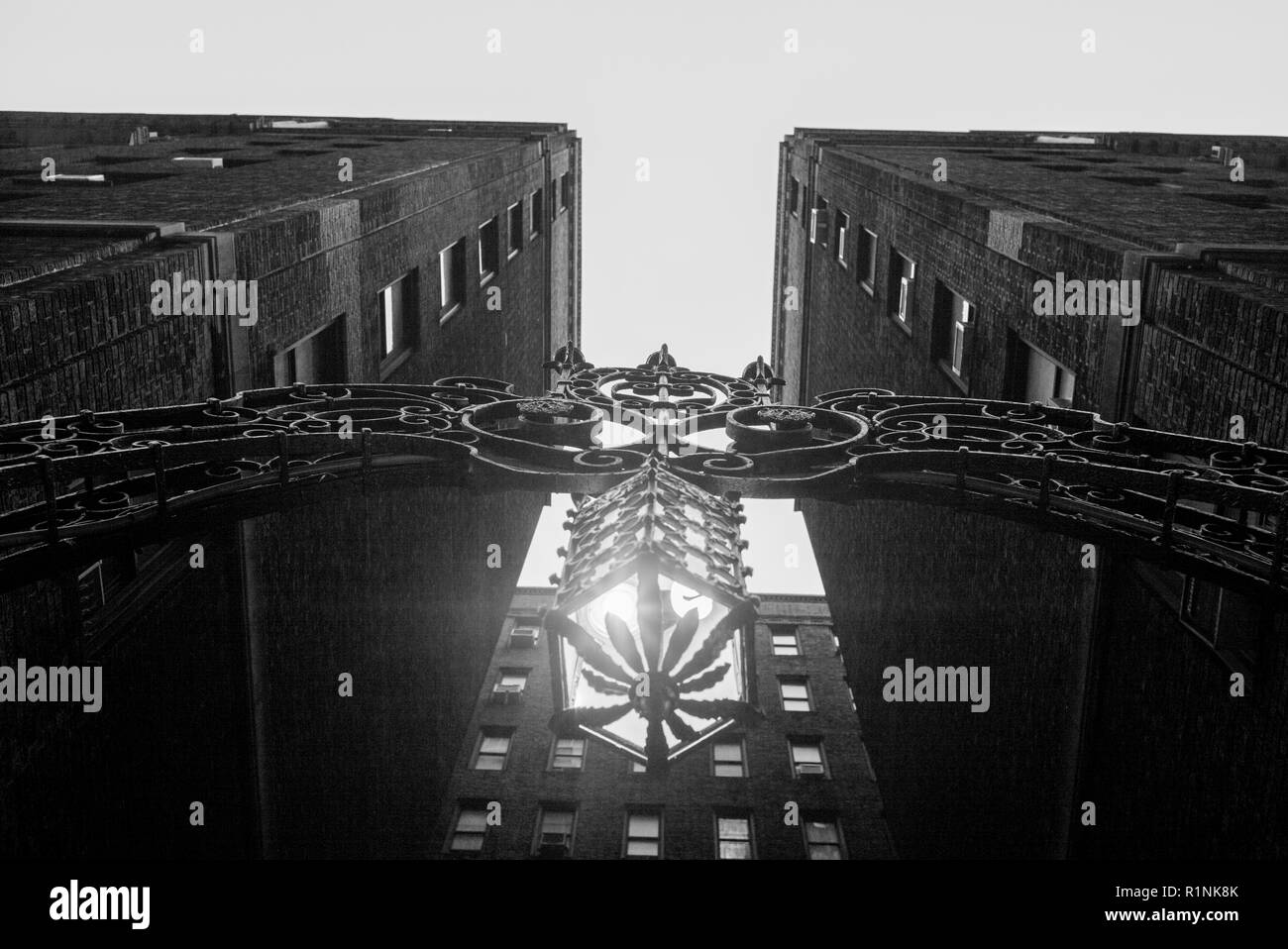 Vista verso l'alto dell'apparecchio di illuminazione e arco di metallo tra edifici di appartamenti, Midtown Manhattan, a New York City, nello Stato di New York, Stati Uniti d'America Foto Stock