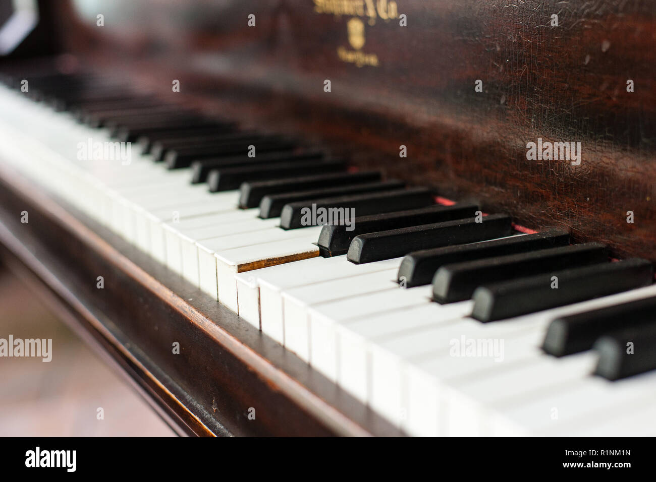Un basso angolo di visione di un'annata pianoforte tastiera, con anni di  usura, centrato su un tasto bloccato Foto stock - Alamy