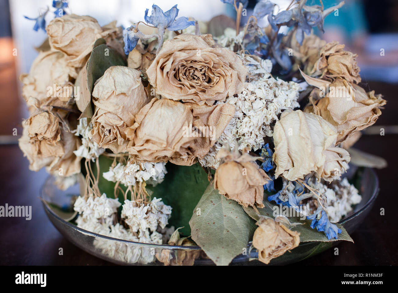 Una vista ingrandita di un essiccati Fiori di colore pallido di rose e altri fiori in un vaso di vetro. Foto Stock