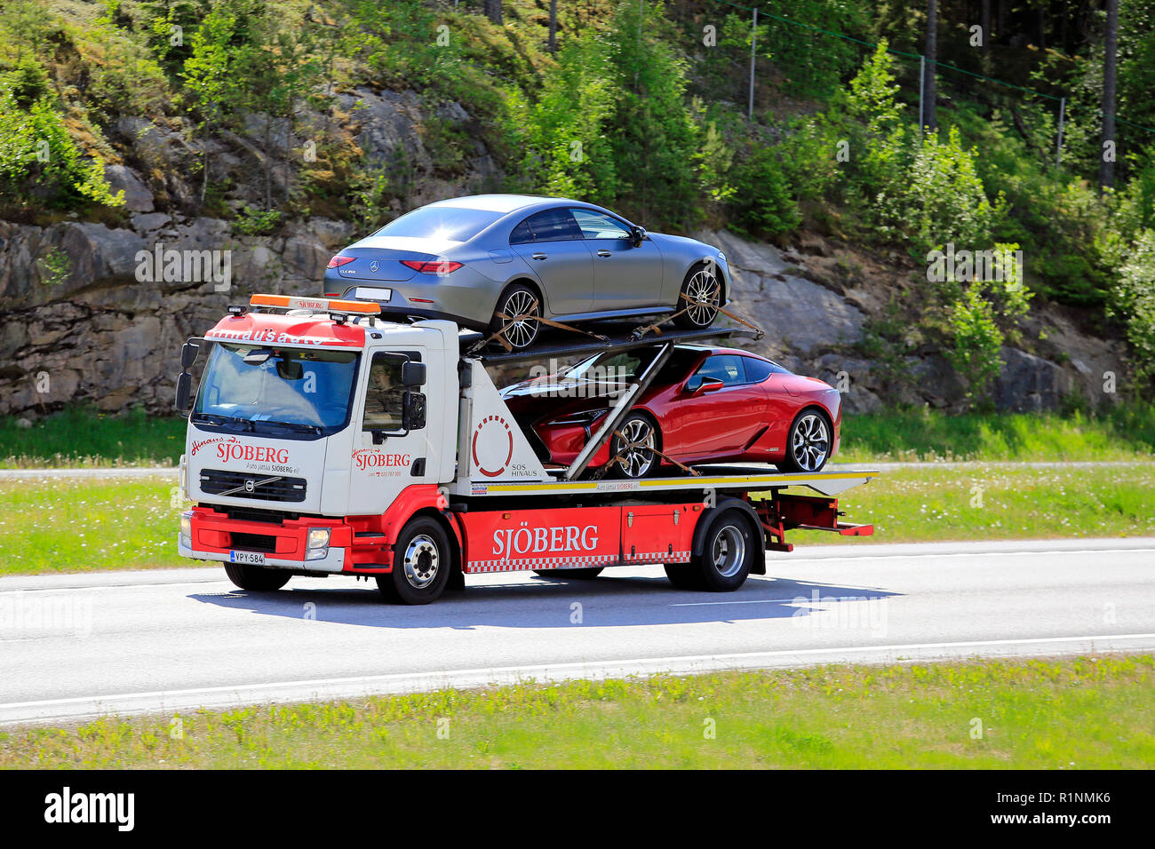 Paimio, Finlandia - 1 Giugno 2018: Volvo flatbed carrello di traino di Hinaus Sjoberg trasporta due nuove vetture in autostrada in estate nel sud della Finlandia. Foto Stock
