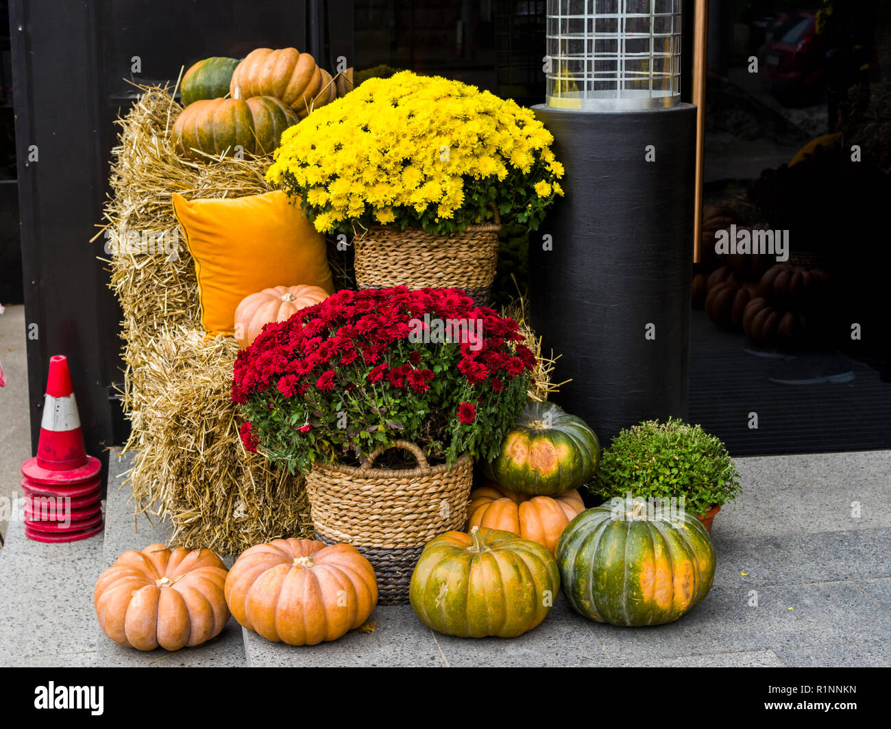 Il fieno e le zucche con fiori in vasi di vimini e cuscini di colore giallo per decorare la vacanza Foto Stock