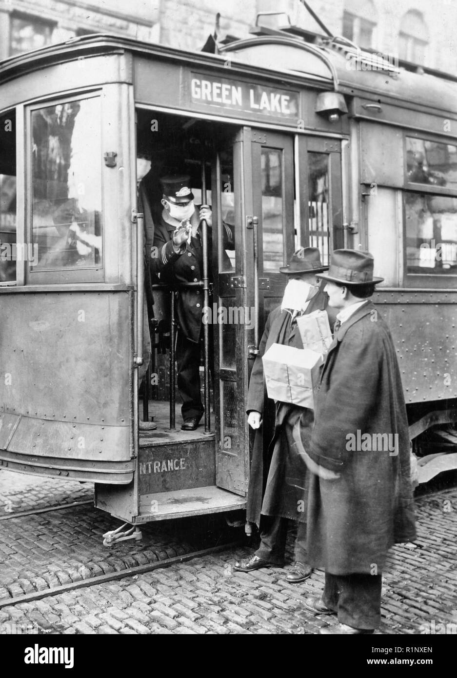 Street car conduttore in Seattle non consentendo ai passeggeri a bordo senza una maschera a causa di un virus influenzale breakout nel 1918. Foto Stock