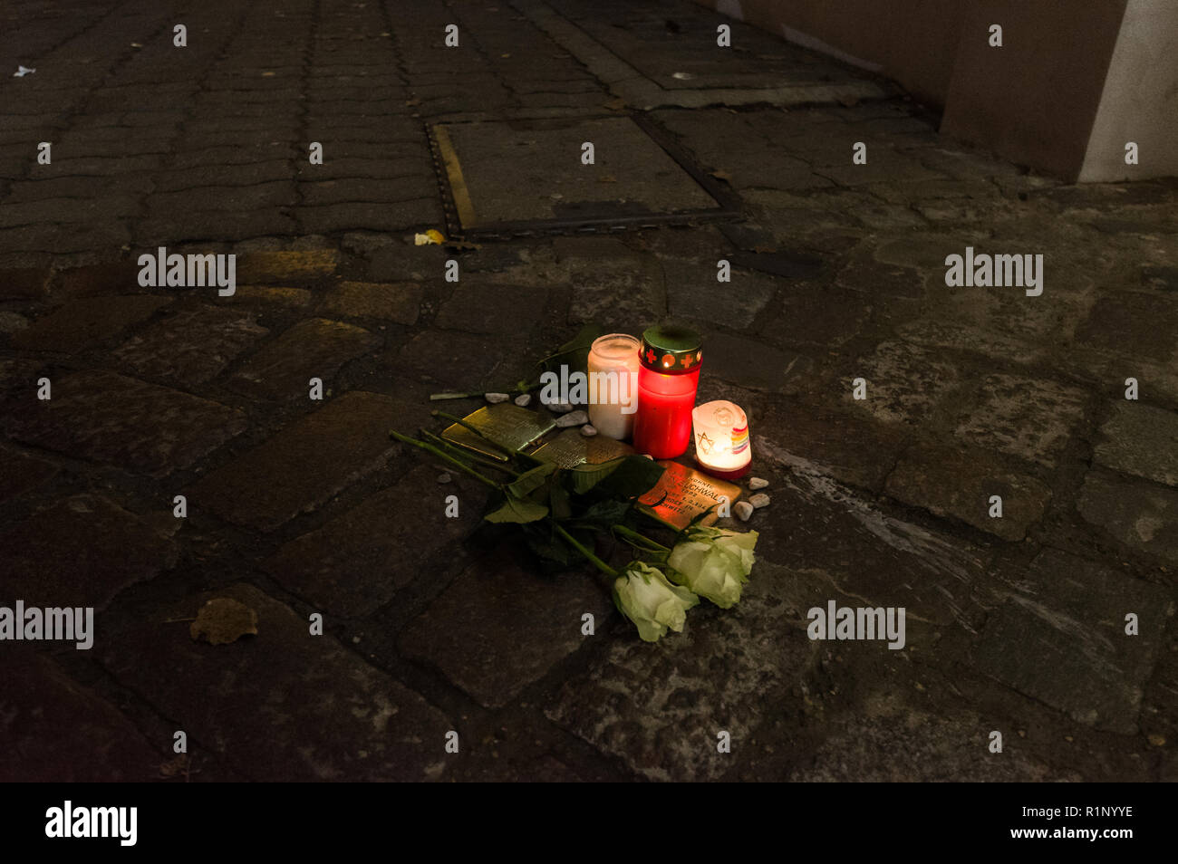 Berlino, Germania - 'Stolpersteine" (letteralmente "tumbling sassi") con i nomi di Ebrei vittime sotto il nazismo adornata con rose e candele Foto Stock
